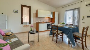 Un espacio habitable compacto con kitchenette, comedor y sofá.