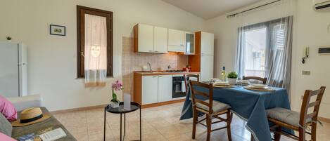 A compact living space with a kitchenette, a dining area, and a sofa.