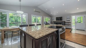A spacious kitchen with a large island, built-in appliances, and a TV.