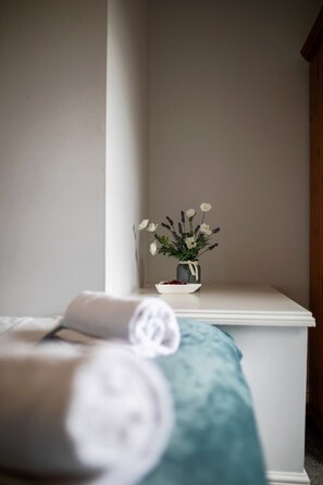 A white bedside table with a vase of white flowers and a bowl of dried flowers. - George's City Centre Apartment - Salisbury (Salisbury)