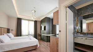 Une chambre d’hôtel avec un lit, un bureau et une kitchenette.
