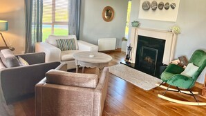A living room with a fireplace, a sofa, a coffee table, and a rocking chair.