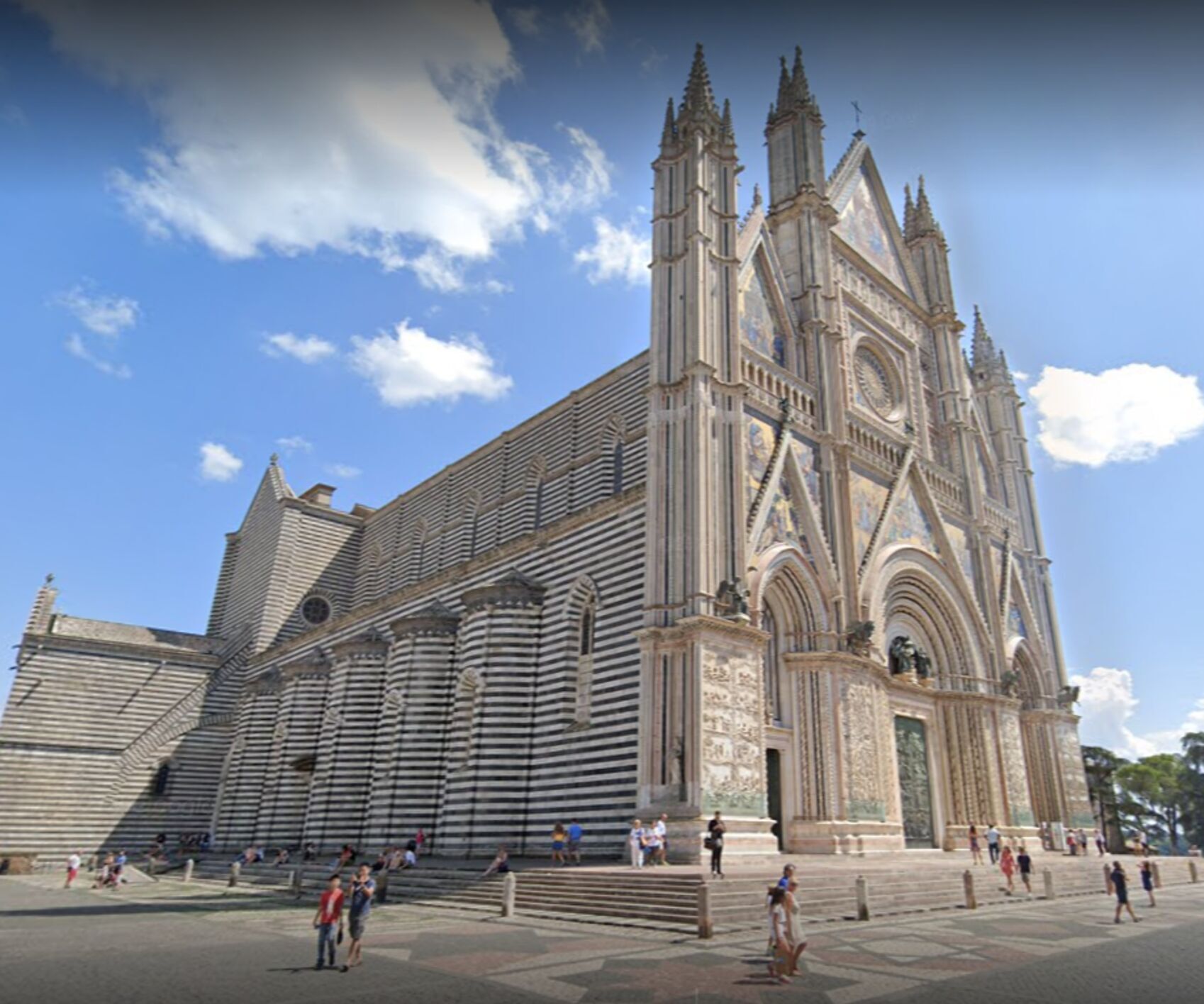 A large cathedral with a prominent facade, multiple towers, and a spacious plaza in front.