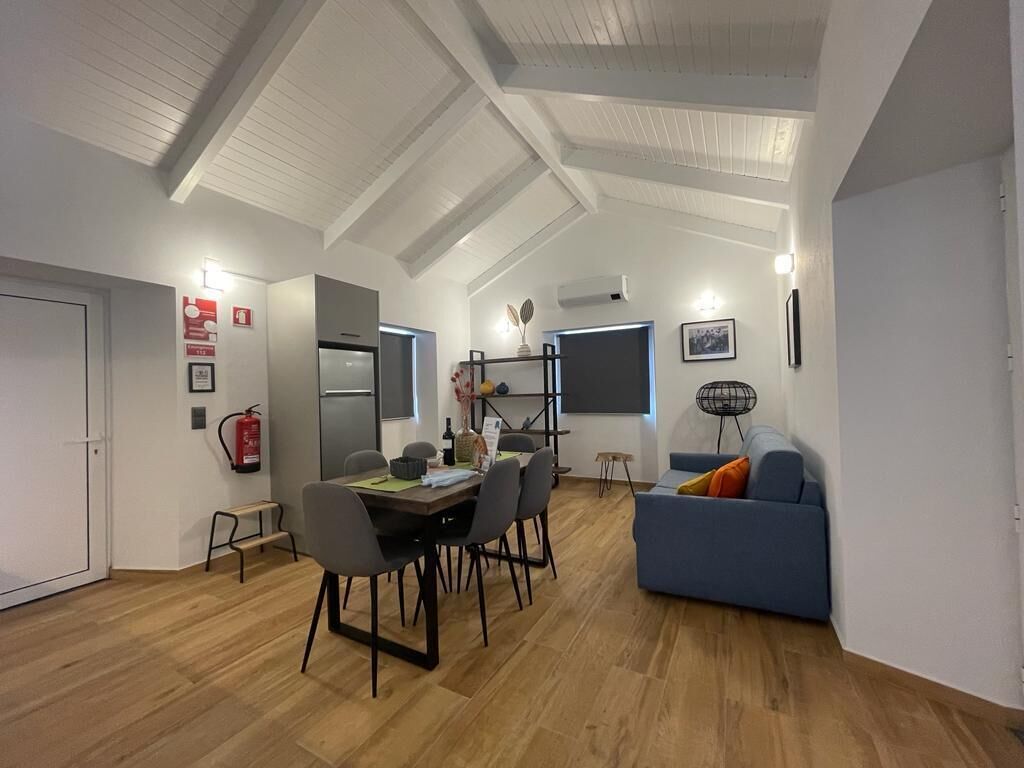 Un espace de vie moderne comprenant un coin repas, un canapé et un ventilateur de plafond.