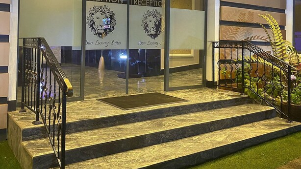 A hotel entrance with glass doors, a marble staircase, and a reception area. - Lion Luxury Suites (Enugu)