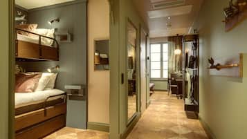 A room with a bunk bed, a desk, a chair, and a mirror.