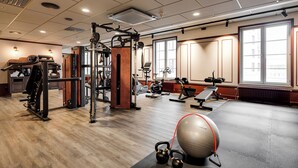 A gym with various exercise equipment, a large exercise ball, and a kettlebell.