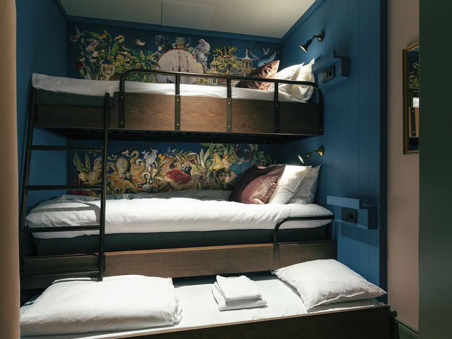 Habitación con literas, un mural en la pared, cabecero de madera y un espejo.