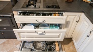 Une cuisine équipée d’une cuisinière, de deux tiroirs et de divers ustensiles de cuisine.