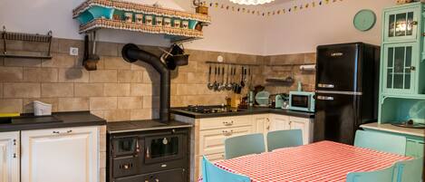 A kitchen with a stove, oven, microwave, refrigerator, and a table with chairs.