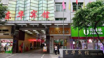 The Donghua Hotel with a modern facade, signage in Chinese, and a visible entrance.