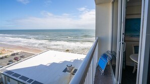 Ein Balkon mit Blick auf den Ozean und den Strand.