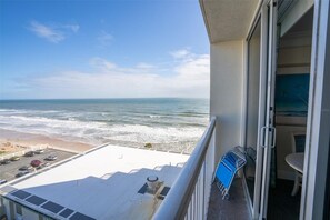 Ein Balkon mit Blick auf den Ozean und den Strand.