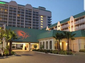 Ein Hotel mit Gründach, großem Logo an der Fassade und mehreren Balkonen.