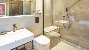 A modern bathroom with a glass-enclosed shower, a white sink, and a toilet. - Host & Stay | The Stables (Yarm)