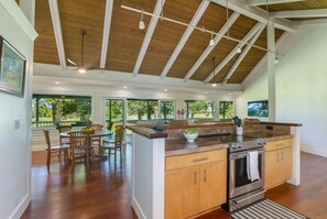 A spacious kitchen with a large island, wooden cabinets, and a built-in oven. - Kealoha - Golf & Lake views, A/C, Pool & Hot Tub (Princeville)