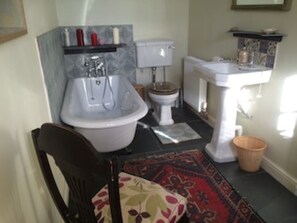 Een bad/douchecombinatie, een haardroger, handdoeken, zeep