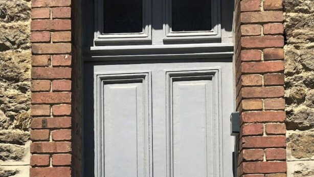 Een dubbele deur met een centraal slot en sierlijk ornament.
