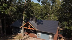 A cabin with a sloped roof, wooden beams, and a stone foundation. - 4 bedroom lake house at Pickwick (Counce)