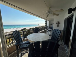 A balcony with a table and chairs, a ceiling fan, and a view of the beach. - "Breakers East 305" Gulf Front 2BR/2BA Beach setup included (Destin)