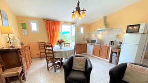 Una sala de estar con comedor, cocina y vistas al exterior.