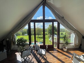 A room with a large window, wooden flooring, and a table with chairs. - La Drutière Farmhouse  is a beautiful rural gem,w/pool (Saint-Sauveur-de-Carrouges)