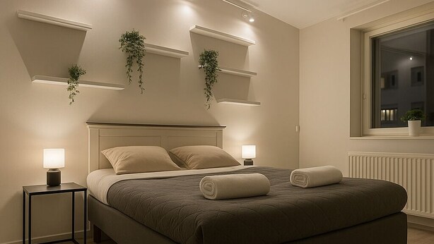 Een moderne slaapkamer met een groot bed, nachtlampjes en wandplanken met planten.