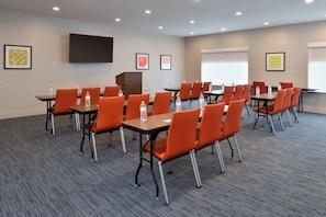 A conference room with multiple tables and chairs, a podium, and a large screen. - Holiday Inn Express and Suites Austin NW Lakeline an IHG Hotel (Austin)