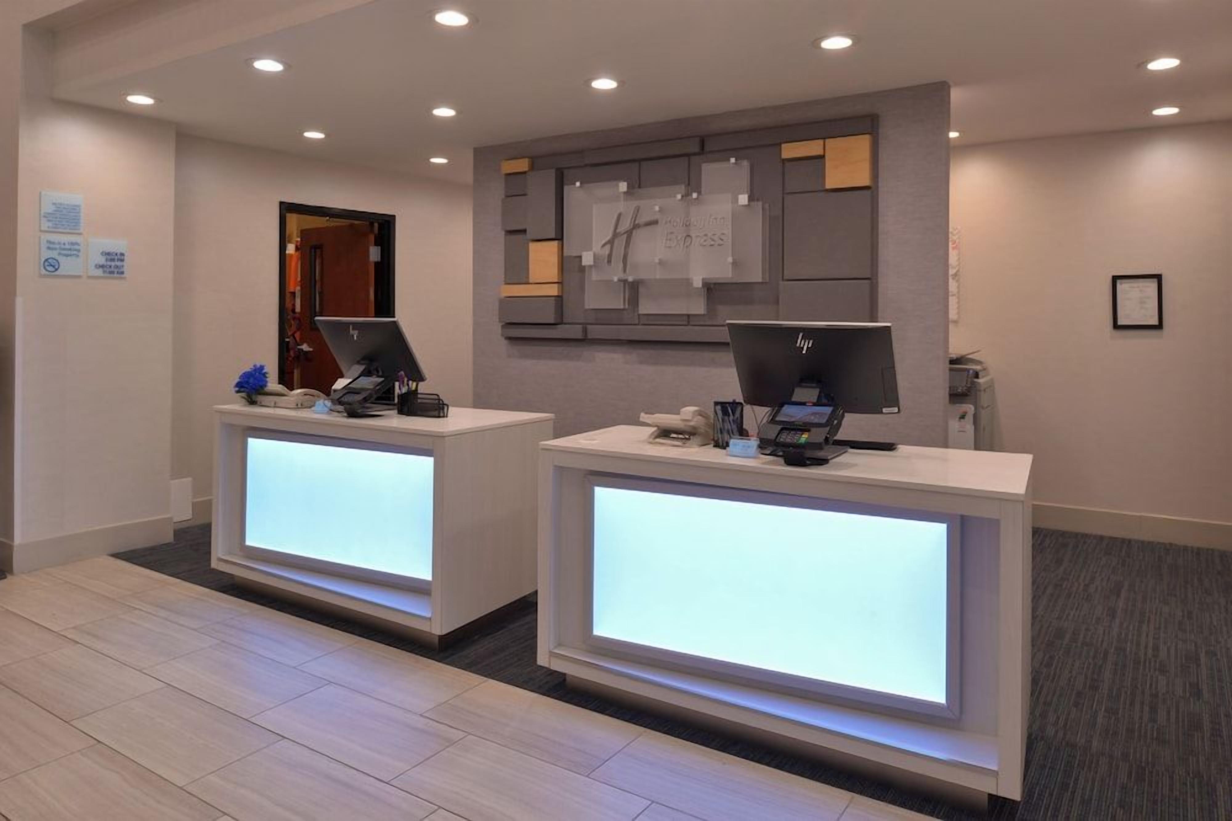 A hotel reception area with two reception desks, each equipped with a computer and a phone.