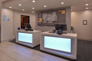 A hotel reception area with two reception desks, each equipped with a computer and a phone. - Holiday Inn Express and Suites Austin NW Lakeline an IHG Hotel (Austin)