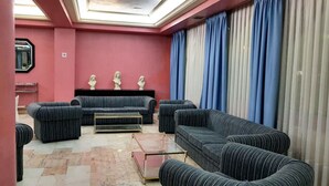 Una sala moderna con sofás a rayas, una mesa de centro de vidrio y una pared de acento roja.