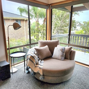 A room with a curved sofa, a small round table, and a floor lamp.