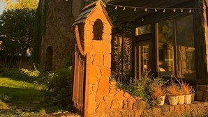 A stone house with a covered porch and a stone staircase leading to the entrance. - Tiny rustic cabin next to the Mississippi River  (St. Cloud)