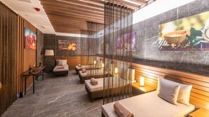 Un spa moderno con paneles de madera, una camilla de masaje y una silla de masaje fijada a la pared.