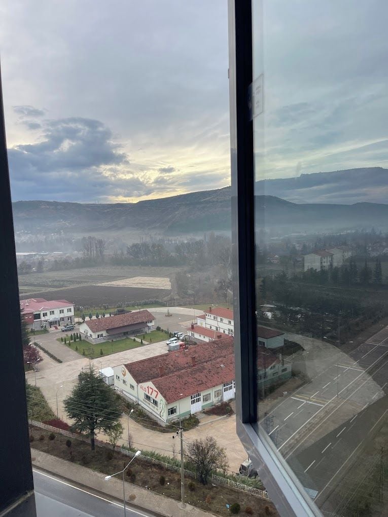 Vista desde una ventana sobre una zona residencial con casas y un estacionamiento.