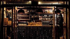 Fachada de madeira com uma placa para Charred Kitchen & Bar.