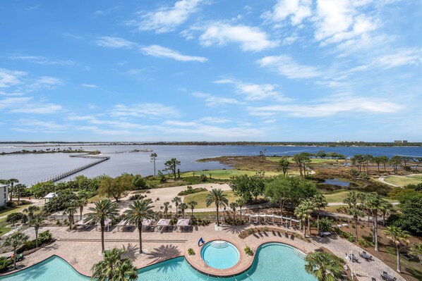 Resort com piscina, área de estar e vista para uma grande massa de água.