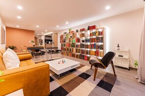 A modern living room with a sofa, a coffee table, a bookshelf, and a piano. - Tranquil Condesa Apt, 2BR/2BA with Rooftop and Gym (Ciudad de México)