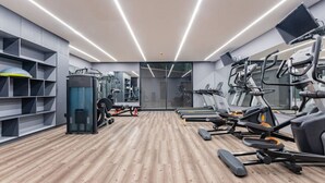 Uma academia moderna com esteiras, elípticos e equipamentos de musculação.