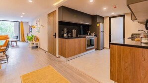 Een moderne keuken met houten kastjes, een inbouwoven en een koelkast.