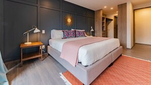 Een moderne slaapkamer met een groot bed, nachtkastjes, een decoratief wandpaneel en een inbouwkast.