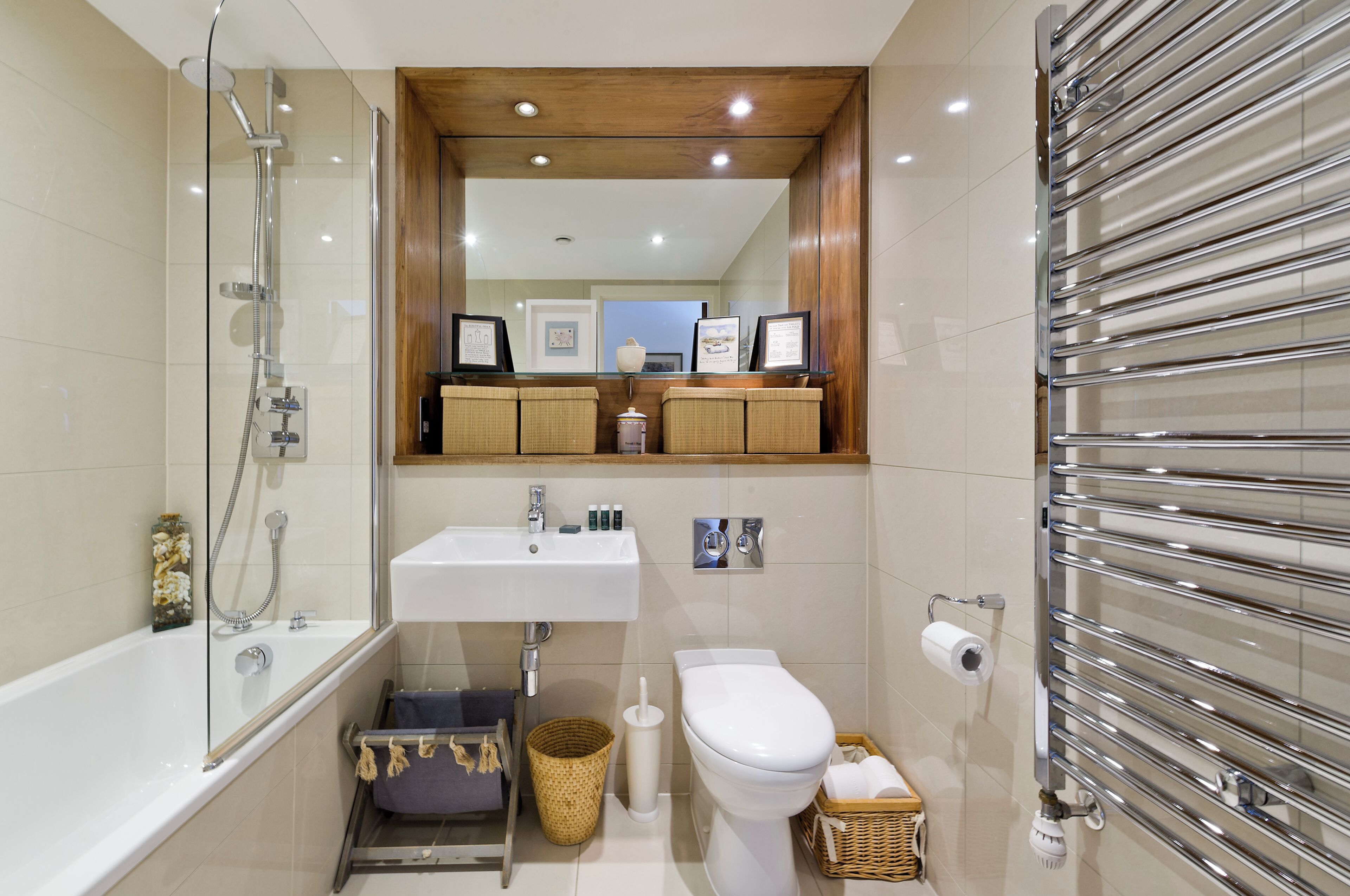 Une salle de bain moderne avec une douche à parois de verre, un lavabo blanc, des toilettes et un porte-serviettes.