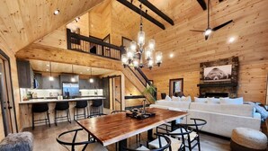 Un intérieur spacieux en bois, comprenant un coin repas, une cuisine et un salon.
