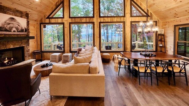 Un intérieur de cabine spacieux, comprenant une grande table à manger, un coin salon confortable et une cheminée.