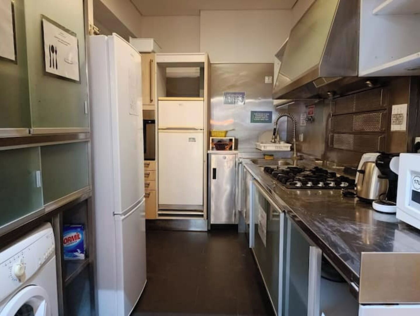 A compact kitchen with a refrigerator, stove, and microwave.