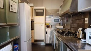 Una cocina compacta con refrigerador, estufa y microondas.