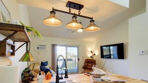 Una cocina moderna con una isla central, un lavaplatos integrado e iluminación colgante.