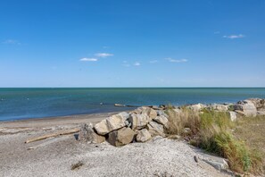 A rocky beach with a clear sky and calm sea.