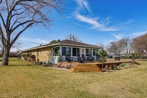 A house with a covered porch, outdoor seating, and a well-maintained lawn.