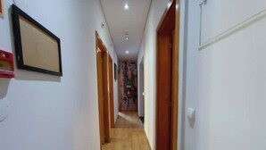 A narrow hallway with wooden flooring and white walls. There are doors on both sides leading to other rooms. - Bairro Alto - 3 bedroom apartment with 2,5 bathrooms (Lisboa)